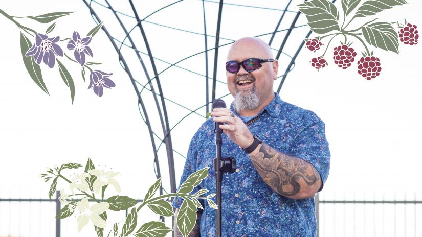 Christian Hampson smiling, standing behind a microphone stand. The photo is overlaid with illustrations of native Australian food plants from the farm.