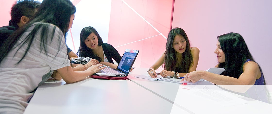 Girls sitting around desk and computer