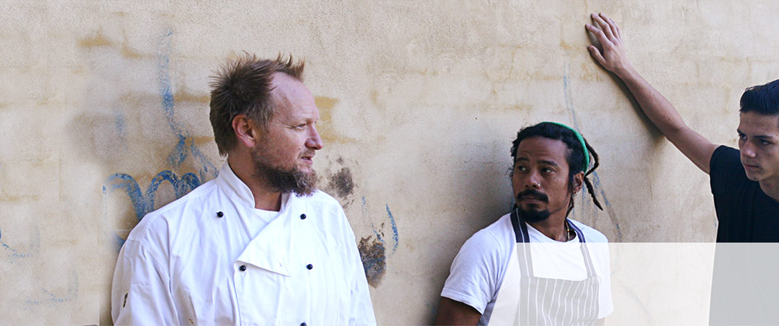 three chefs lined up against wall