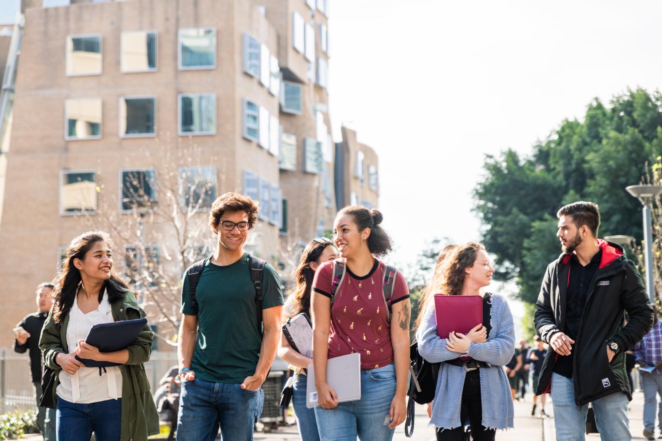 International students walking to class, talking and smiling.
