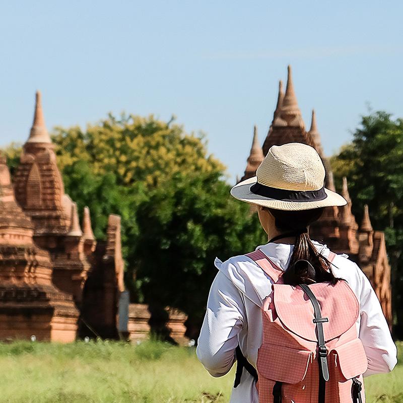 Young backpacker with hat looking at temples and pagoda in Myanmar.