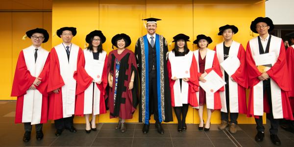 Distinguished Professor Jie Lu and Vice Chancellor Attila Brungs with a group of happy graduates