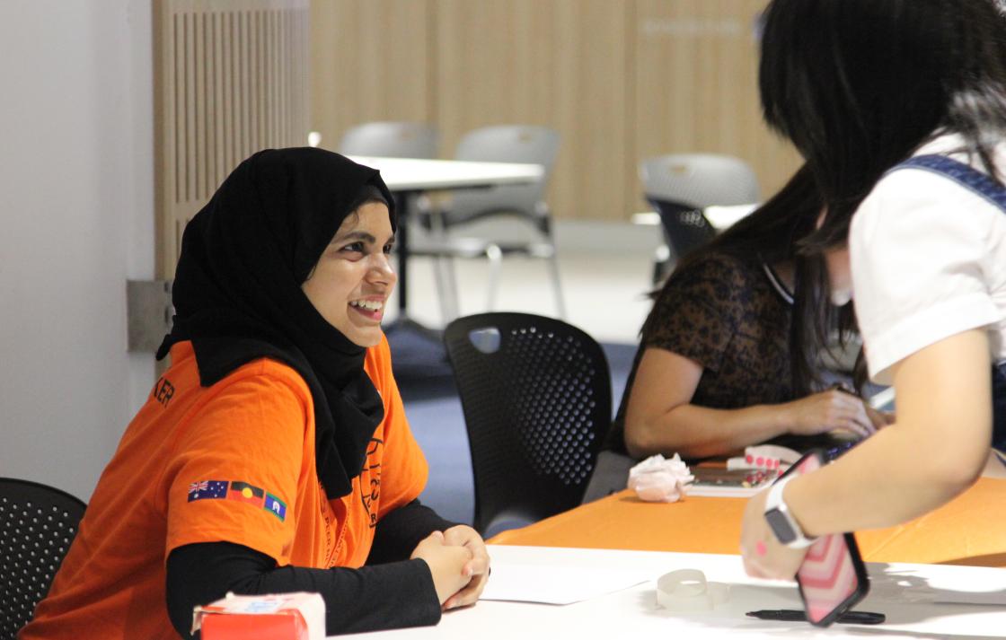 A Peer Networker smiling at a student during event registration. 