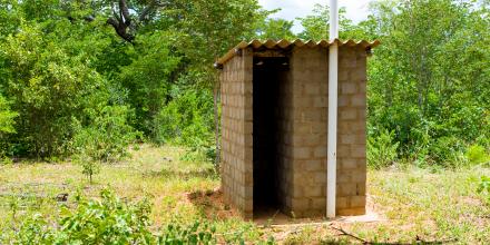 Small brick toilet block near bush