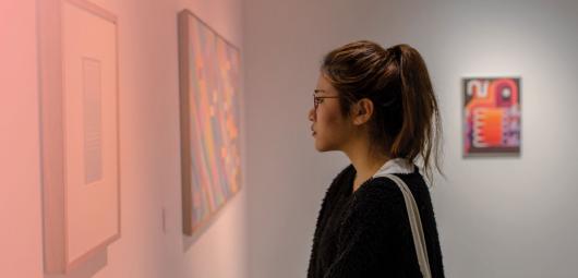 A woman looking at art in a gallery