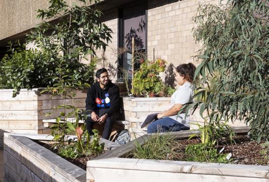 A man and woman sitting in the Waraburra Nura garden, smiling and enjoying the sunshine