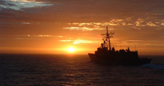 A naval ship at sunset.