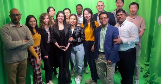 Group of PhD student in front of a green curtain