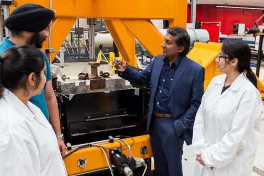 Prof Buddhima Indraratna at UTS Tech Lab demonstrating machinery to other Civil Engineers
