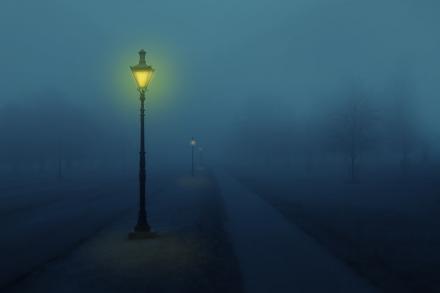 A street lamp glowing on a foggy night
