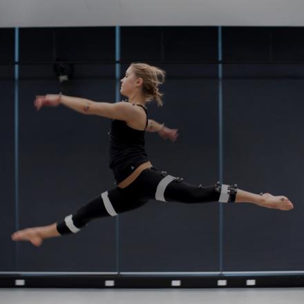 Dancer leaping in the air in a movement studio