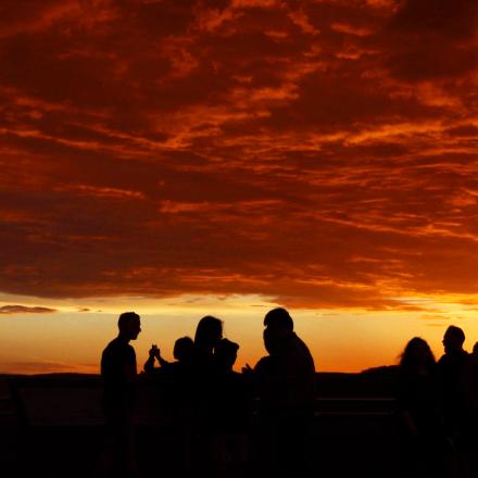 People viewing bushfires, silhouette against red sky