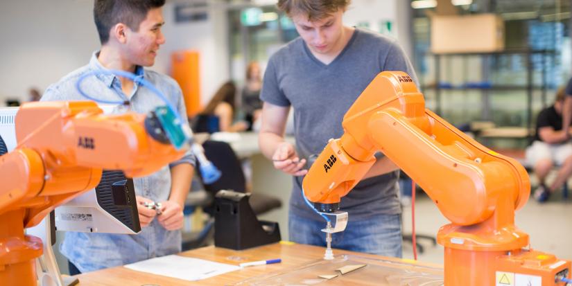 Students interact with robotic arms