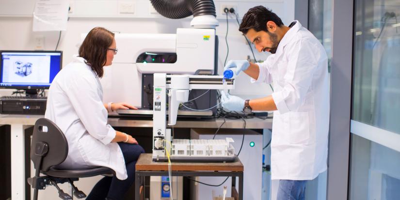 A female and a male researcher working together inside a lab