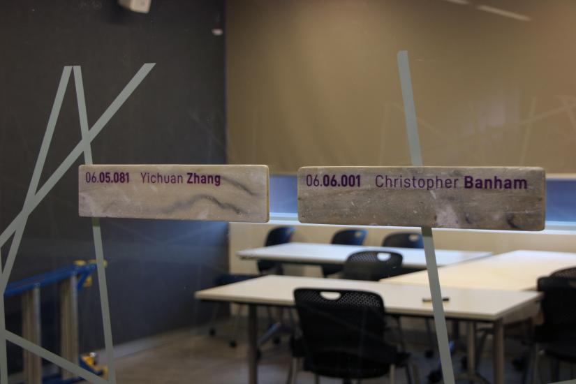 Two office signs made of EPS attached to a glass wall