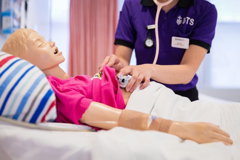 Training manikin on a bed being used for student training  