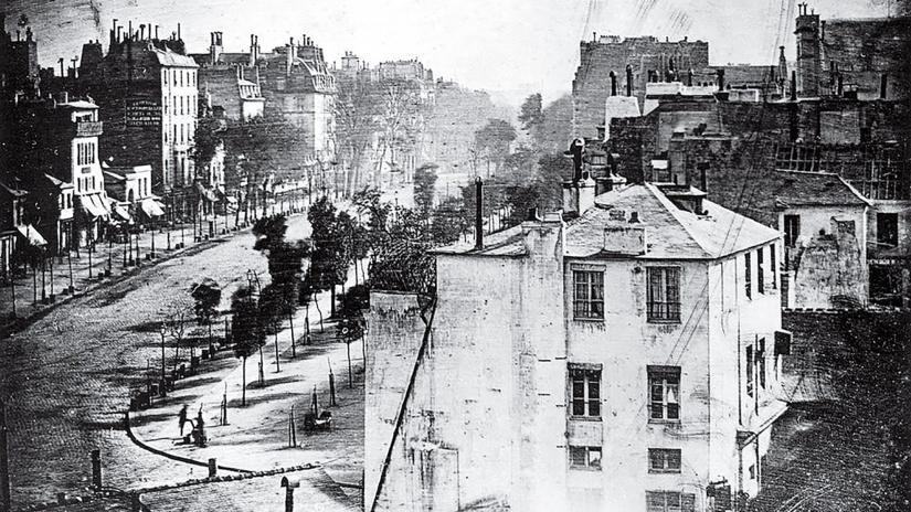 Grainy black-and-white photo of a Paris street with two figures visible