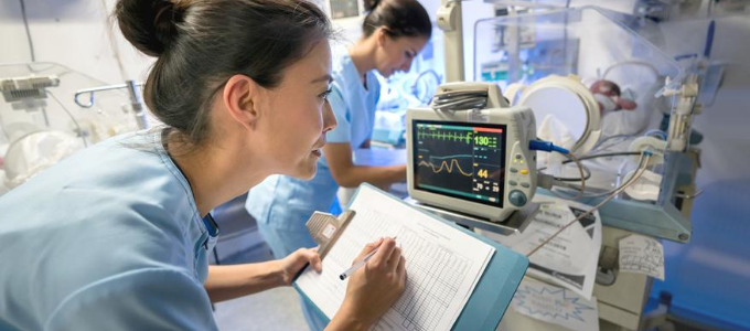 Nurse recording patient information on chart