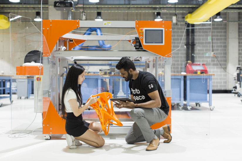 Two students looking at a 3D printed chair inside UTS Protospace
