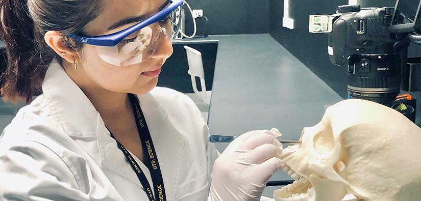 Ayusha Dahal with a skull in the Forensic Science Lab