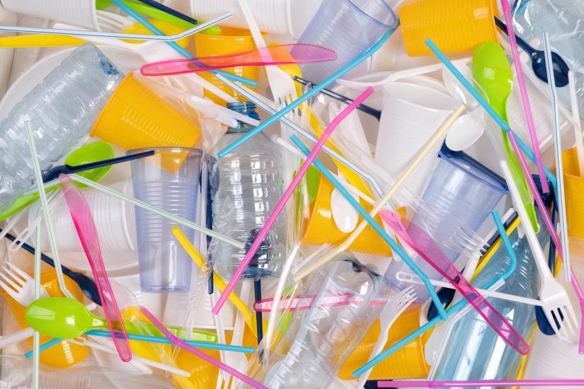 Plastic bottles, cups, cutlery and colorful plastic straws