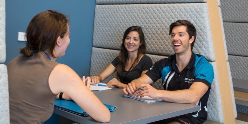 Three UTS students sitting at a table and chatting