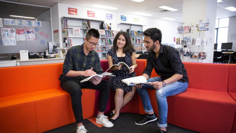 Three UTS College students reading in the library