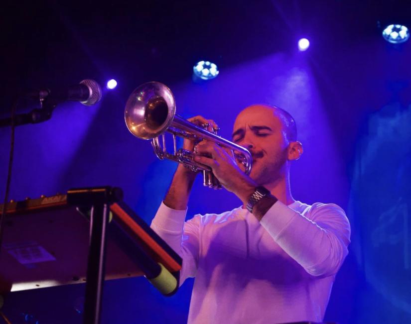 A student plays trumpet on stage