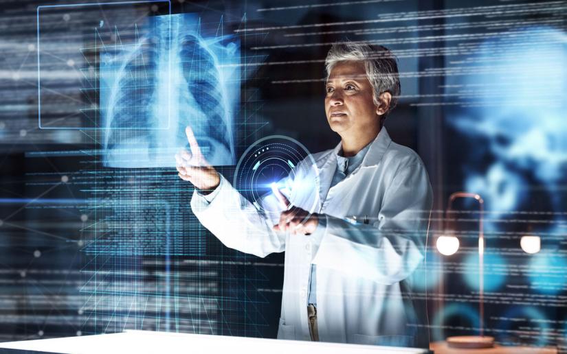 A doctor examines a lung xray in a hologram setting surrounded by images of data.