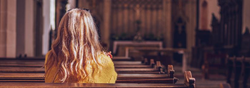 Woman sitting in a church. Adobe Stock image