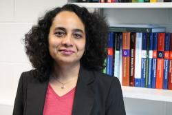 A picture of A/Prof Arti Argawal standing in front of a book shelf 