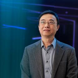 Distinguished Professor CT Lin looking diagonally upwards. The background is darkened with long blue and purple neon lights