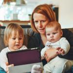 Parent and two babies reading a tablet