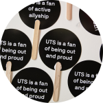 Hand held fans with the phrase 'UTS is a fan of being out and proud' printed on them.