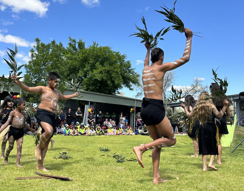 A group of Indigenous dancers perform for a crowd