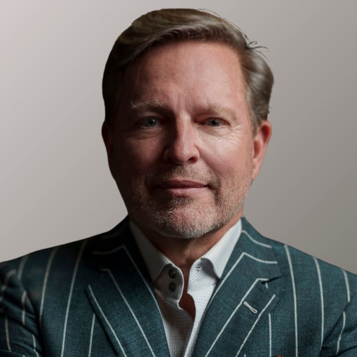 Portrait of Verne Harnish. He's wearing a green pinstripe suit.