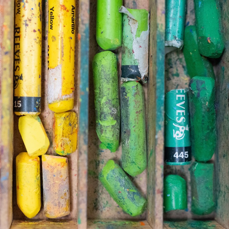 Coloured crayons in a drawer.
