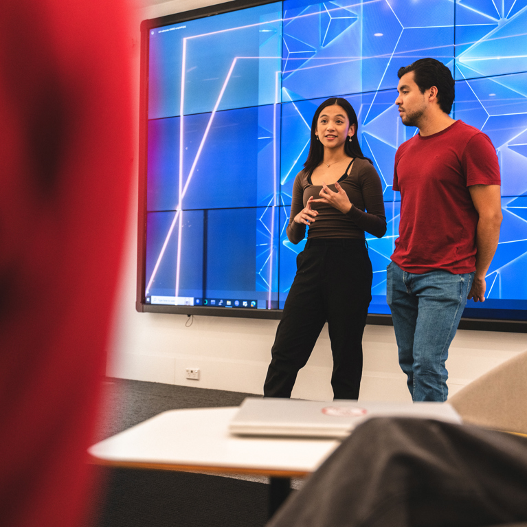 Female and male students presenting in UTS Data Lounge.