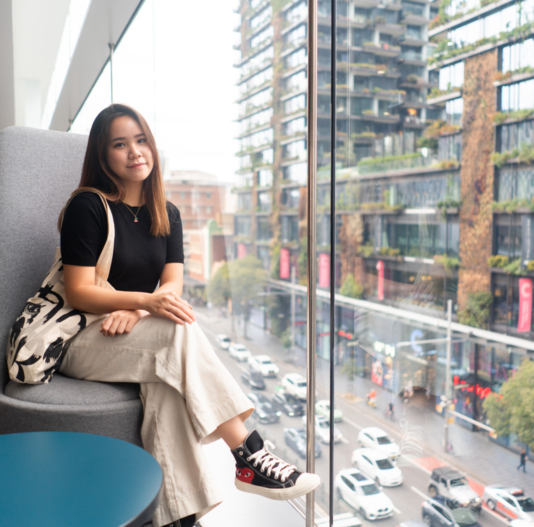Under-18 UTS international student sitting by a glass window.