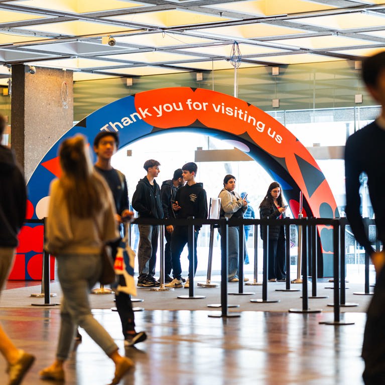 Two UTS prospective students stand side by side at university Open Day event, enjoying the atmosphere and engaging with the surrounding crowd.