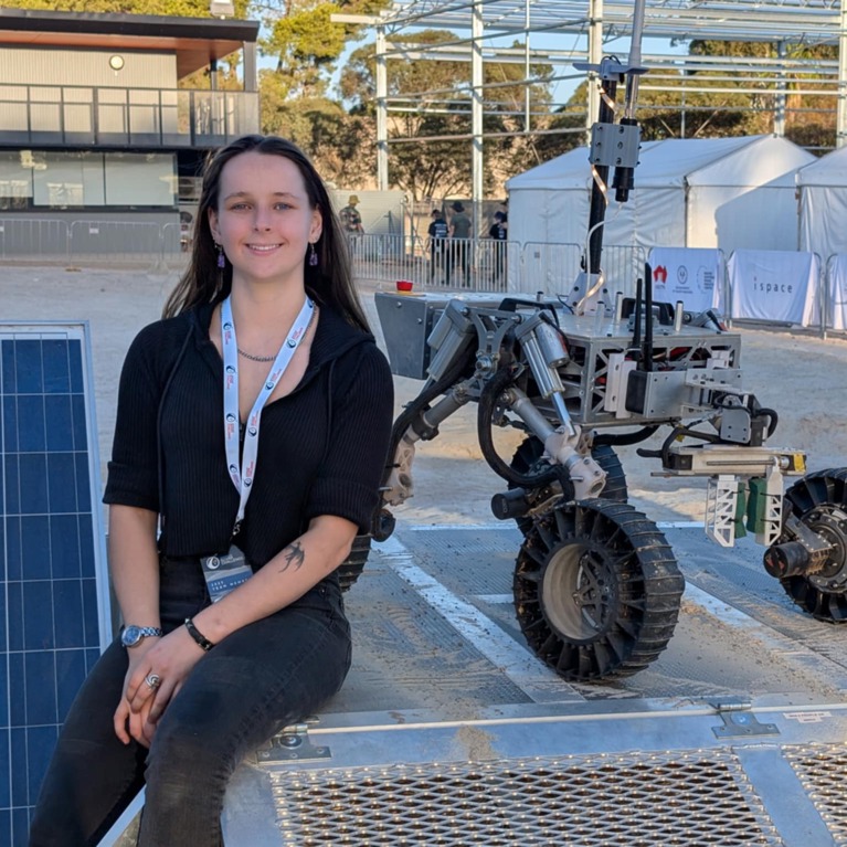 Engineering student Issy Pitt sits alongside the University of Technology Sydney Rover.