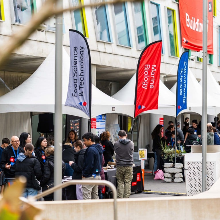 A diverse crowd of people gathered outside a large UTS building for Open Day.