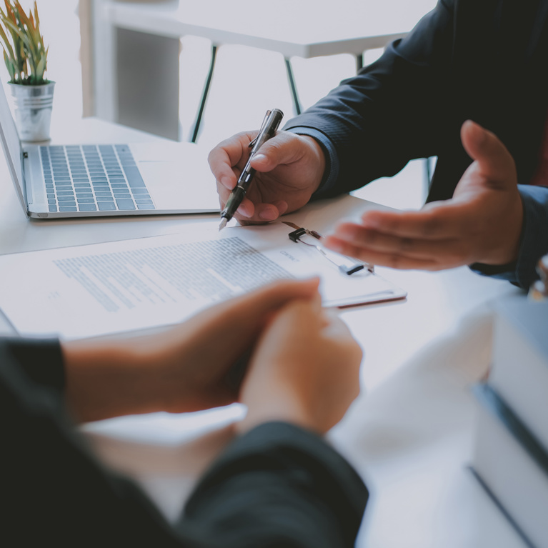 Two people at a desk with pen and papers