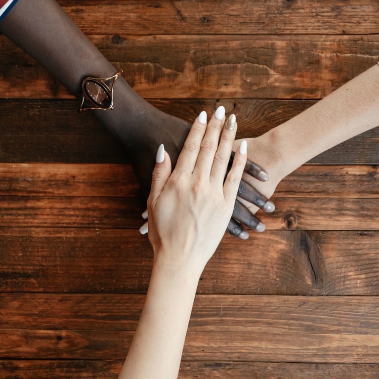 Three diverse hands stacked together symbolising unity and diversity. Picture: Alexander Suhorucov, Pexels