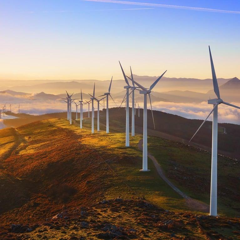Wind farm on top of a hill at sunset