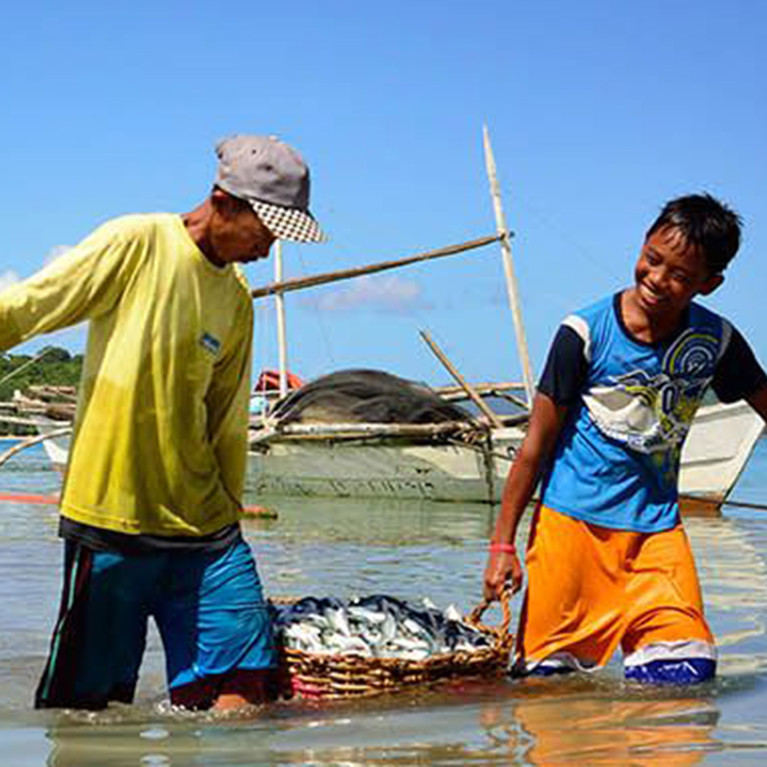 People hauling a net through water