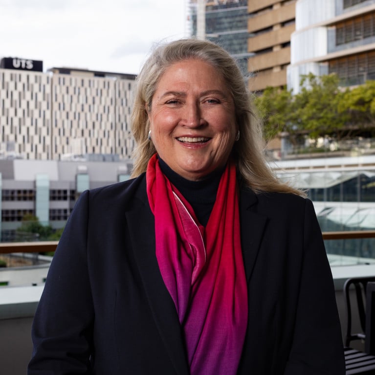 Simone Clark smiling and looking at the camera with UTS buildings in the background