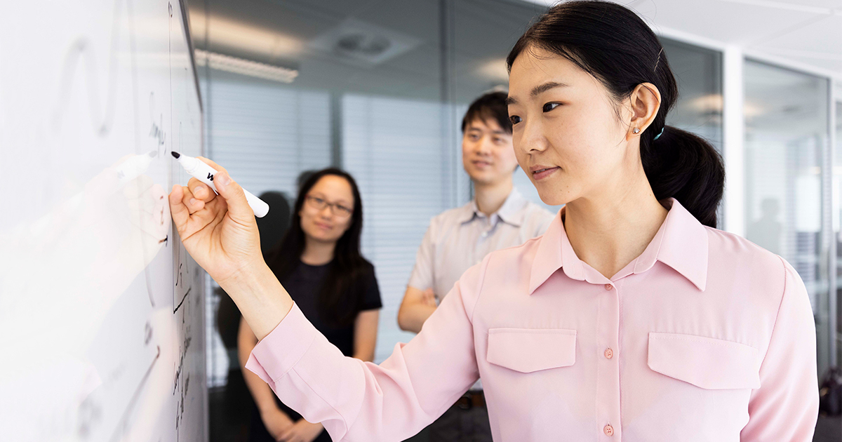 university students collaborating at a whiteboard