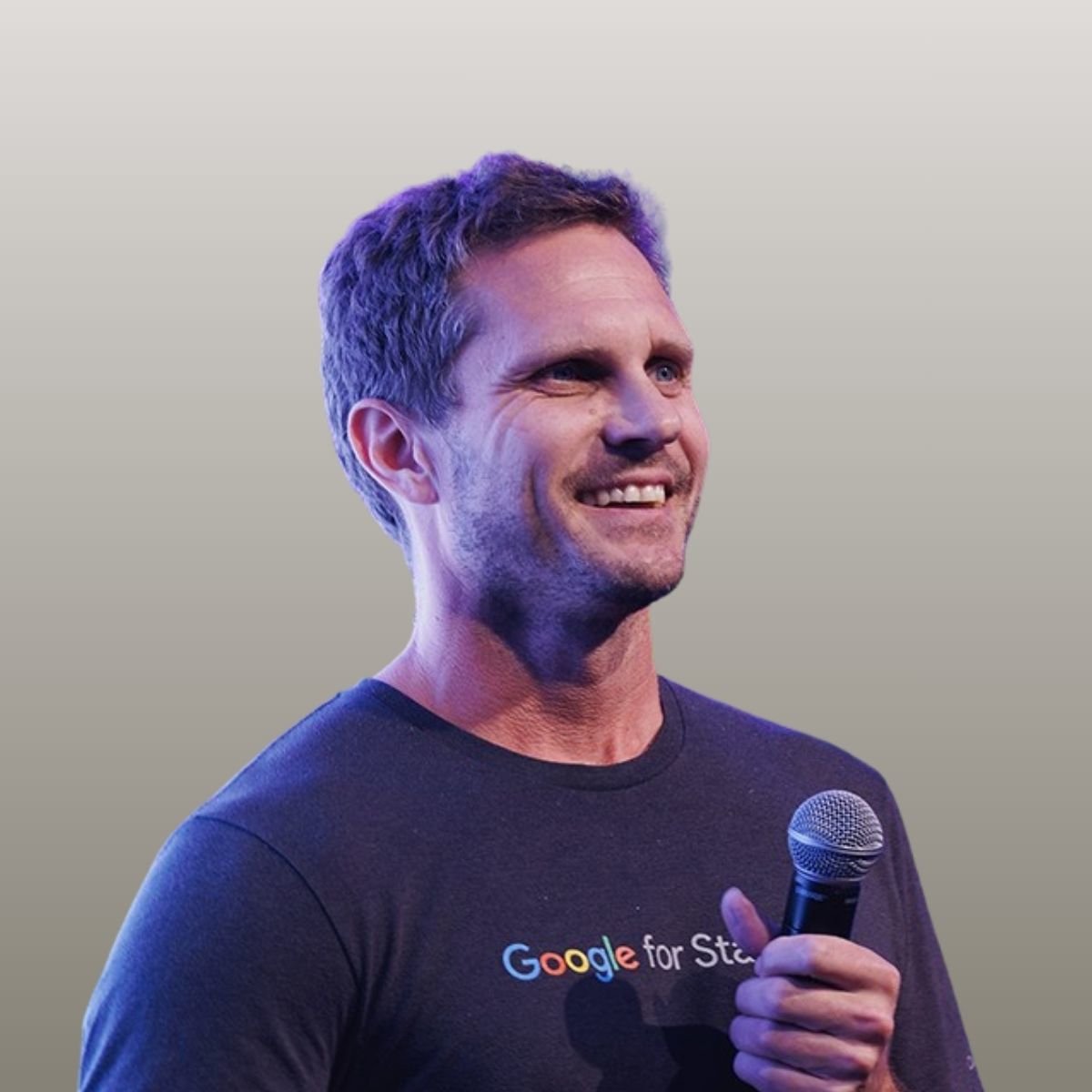 Mike Langford looking to the right holding a microphone