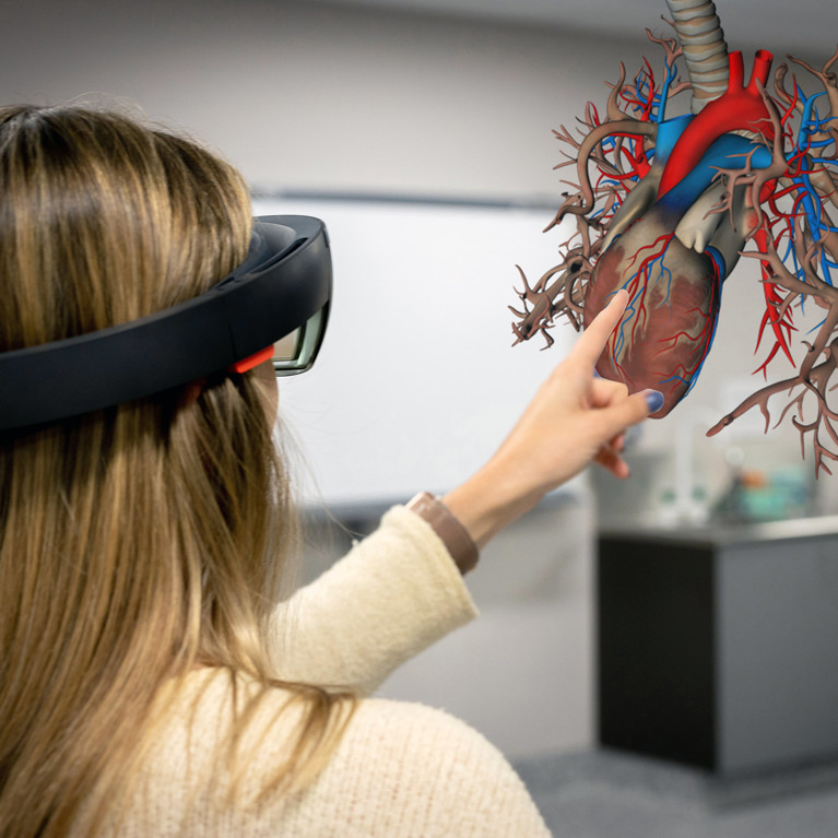 UTS Health student using a virtual reality headset to view a 3 dimensional image of a human heart.